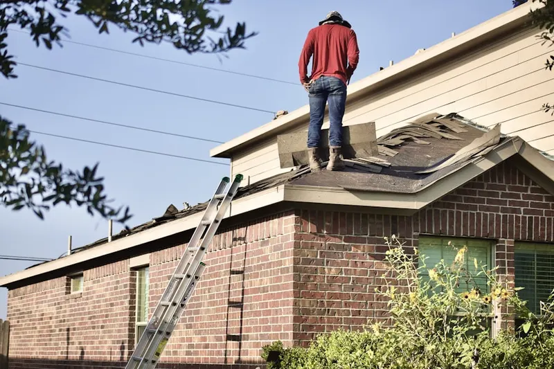 Professional roofer working on a residential roof in Honore